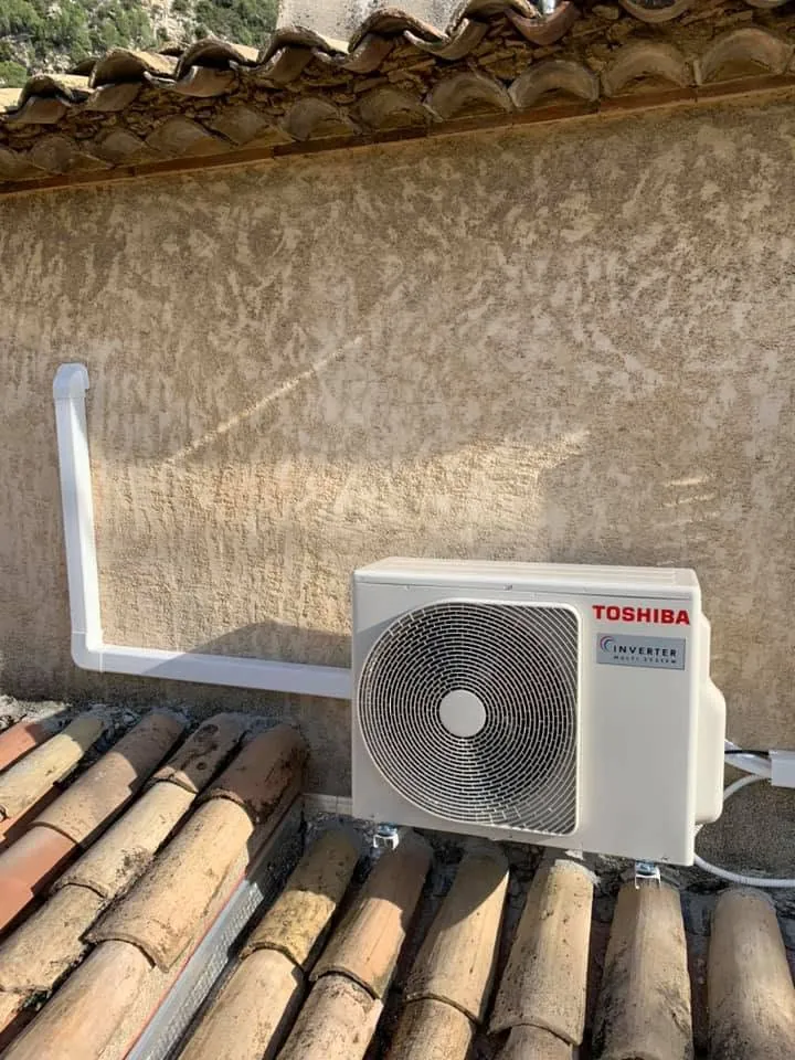 Groupe extérieur de climatisation Toshiba posé sur une toiture en tuiles