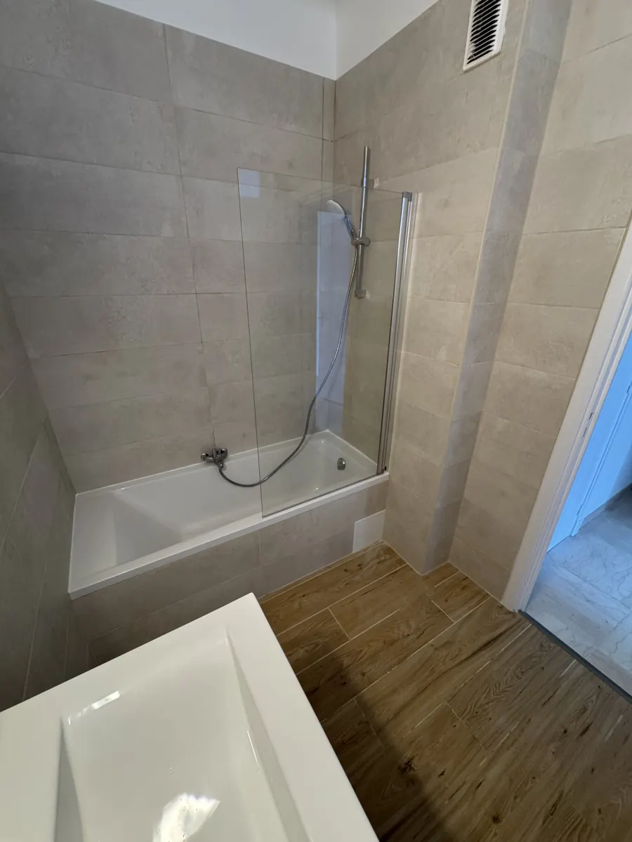 Douche avec paroi vitrée et carrelage beige
