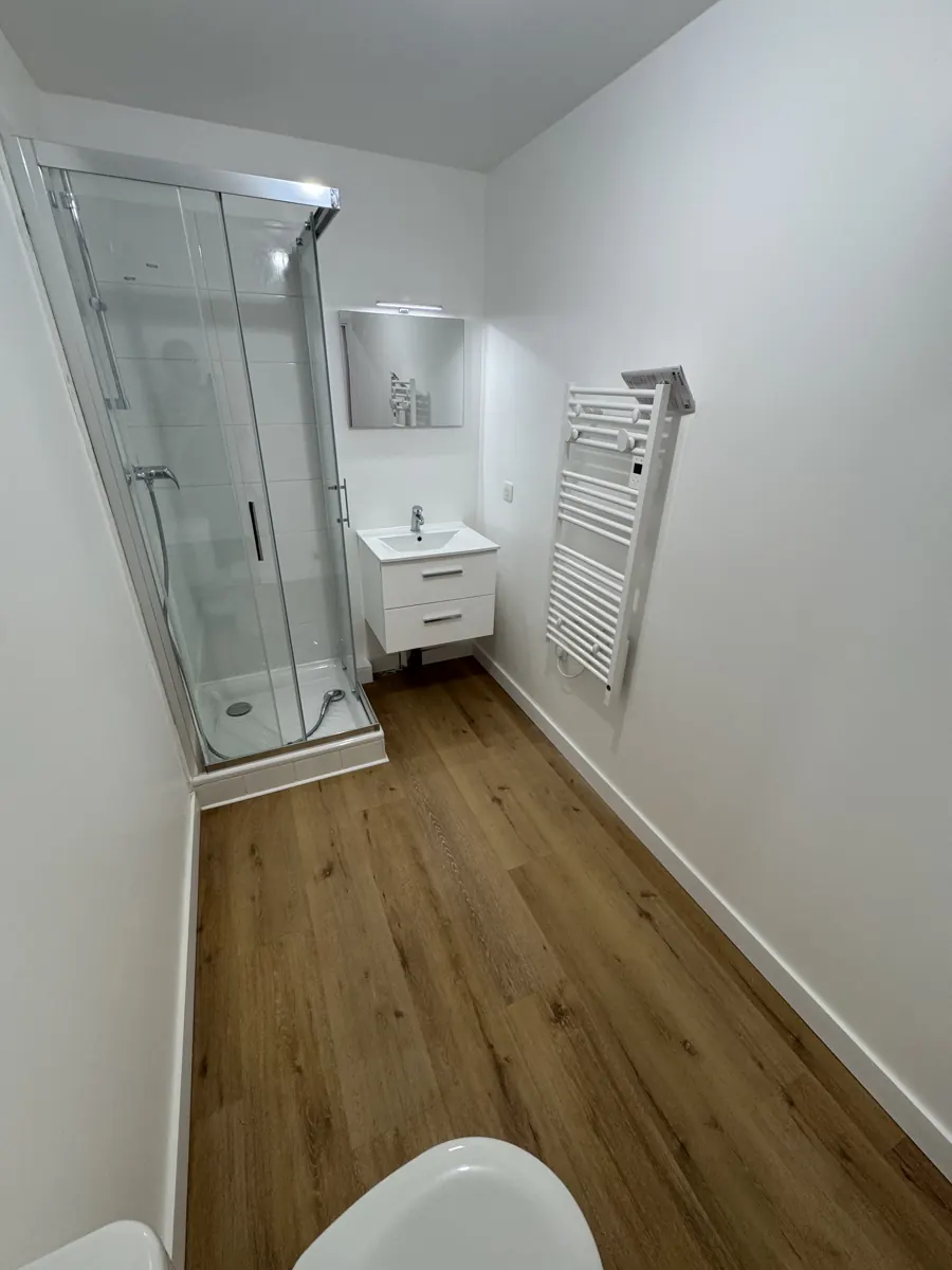 Salle d'eau avec cabine de douche et sèche-serviettes
