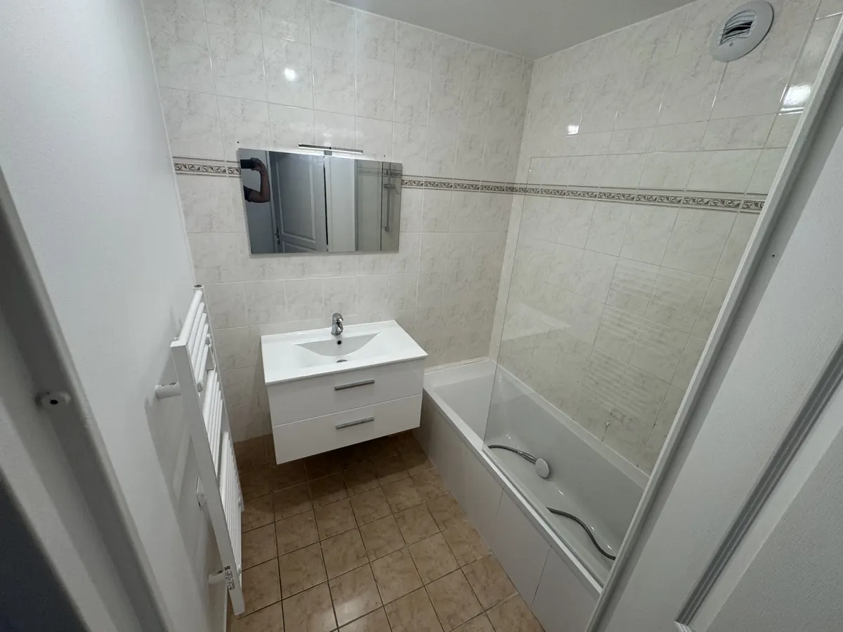 Salle de bain rénovée avec baignoire et meuble vasque